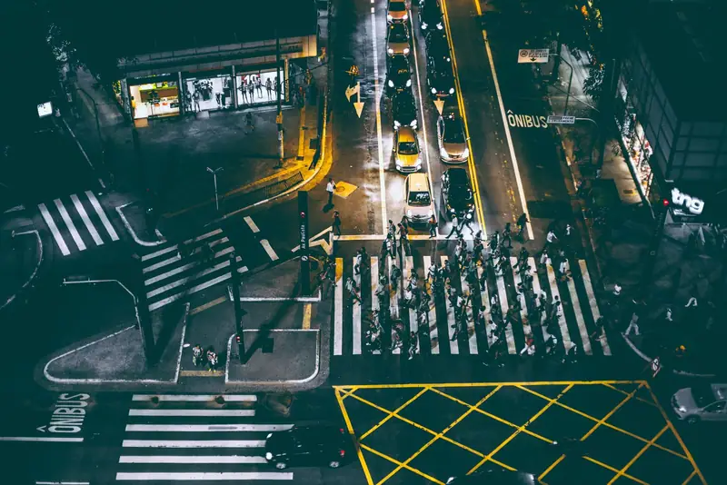 Aerial view of pedestrians crossing a city street at night